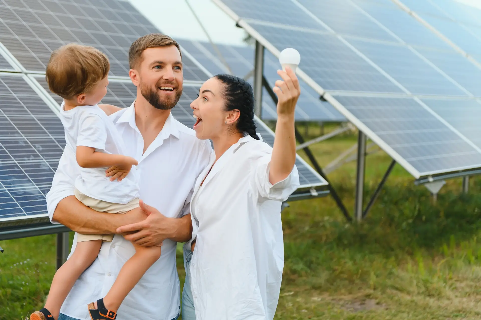 Solar energy concept. A young, happy family is standing near solar panels